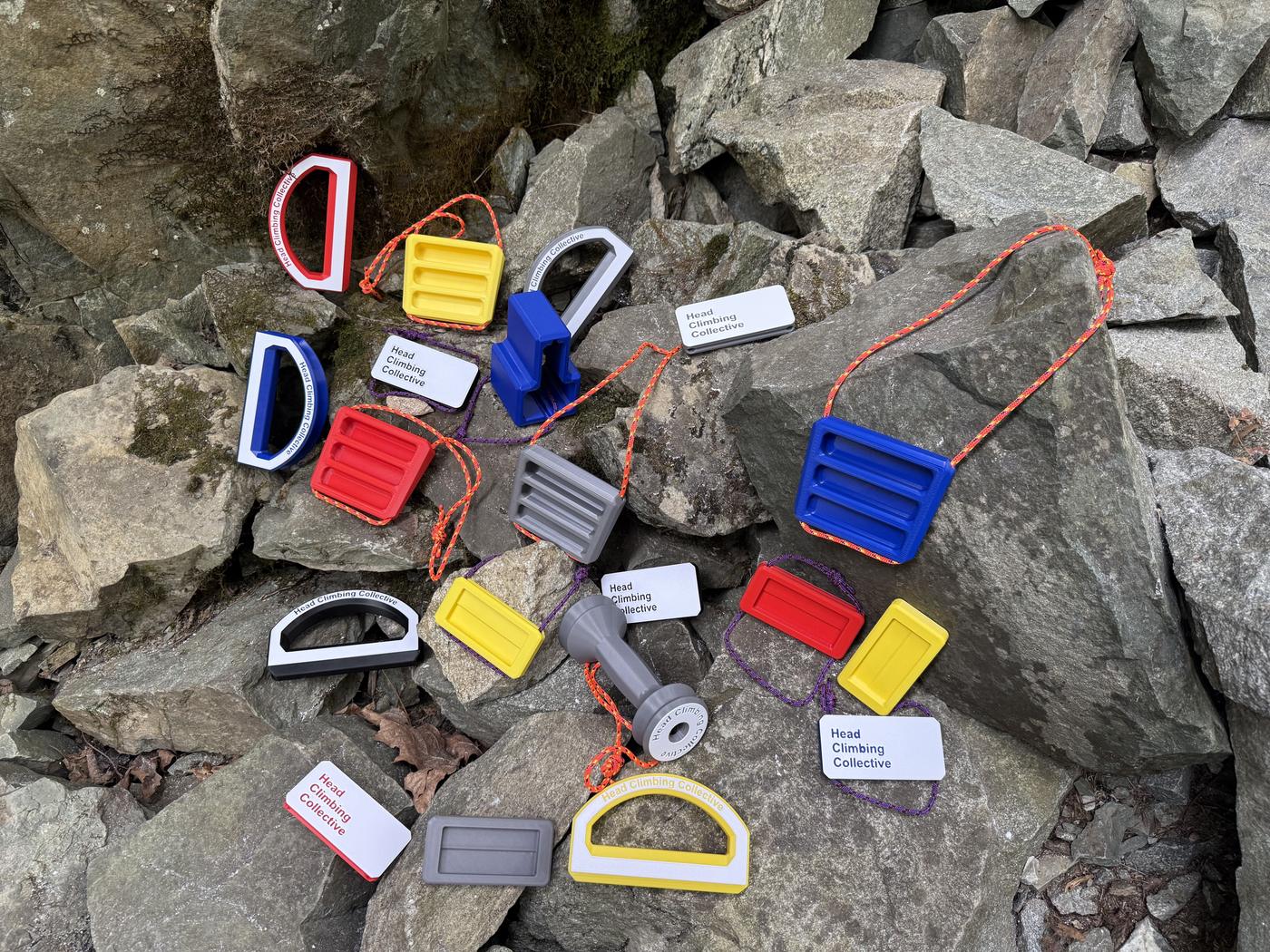 Head Climbing Collective crimp blocks, rails, pinch blocks, wrist trainers and gear racks laid out on rocks