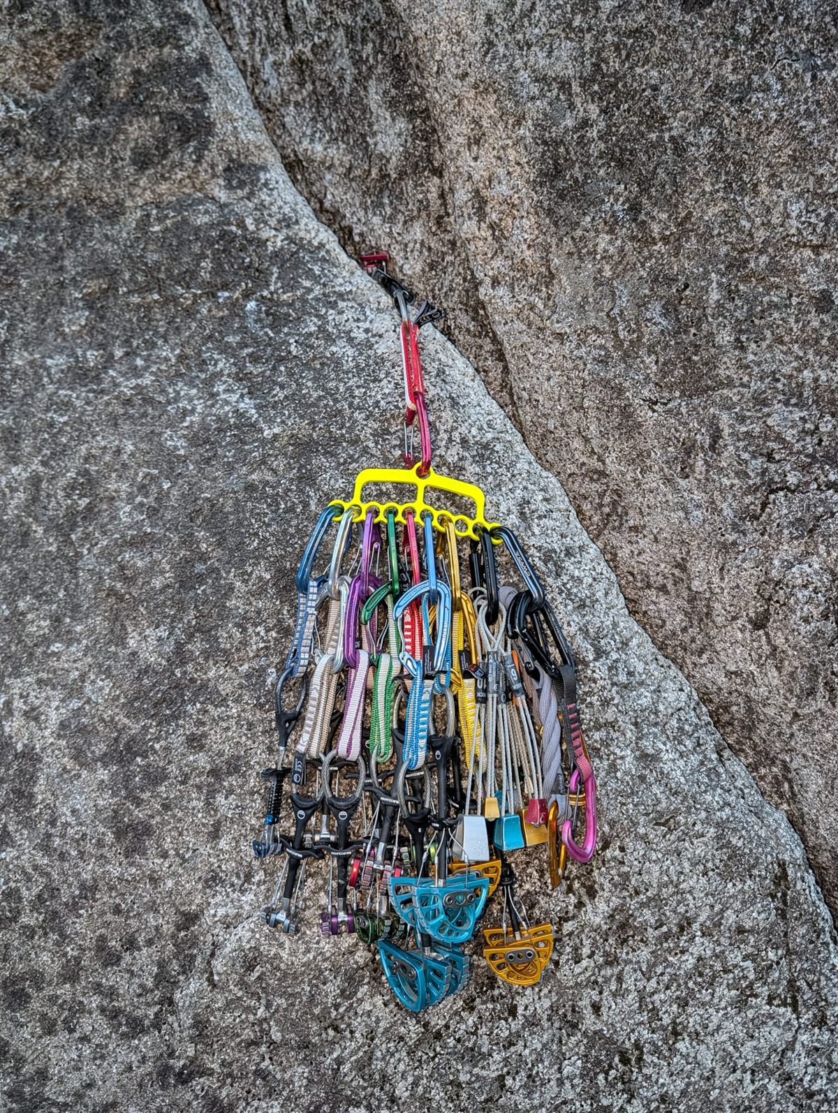 CrackRack loaded with a full trad rack, clipped to a cam in a granite crack